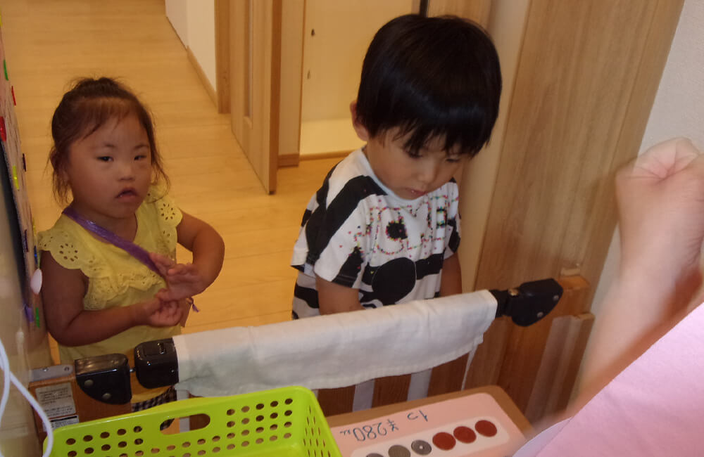 夏休みはお買い物体験を実施。手作りのお金を使って遊びながら買い物の練習を行います（オレンジ）